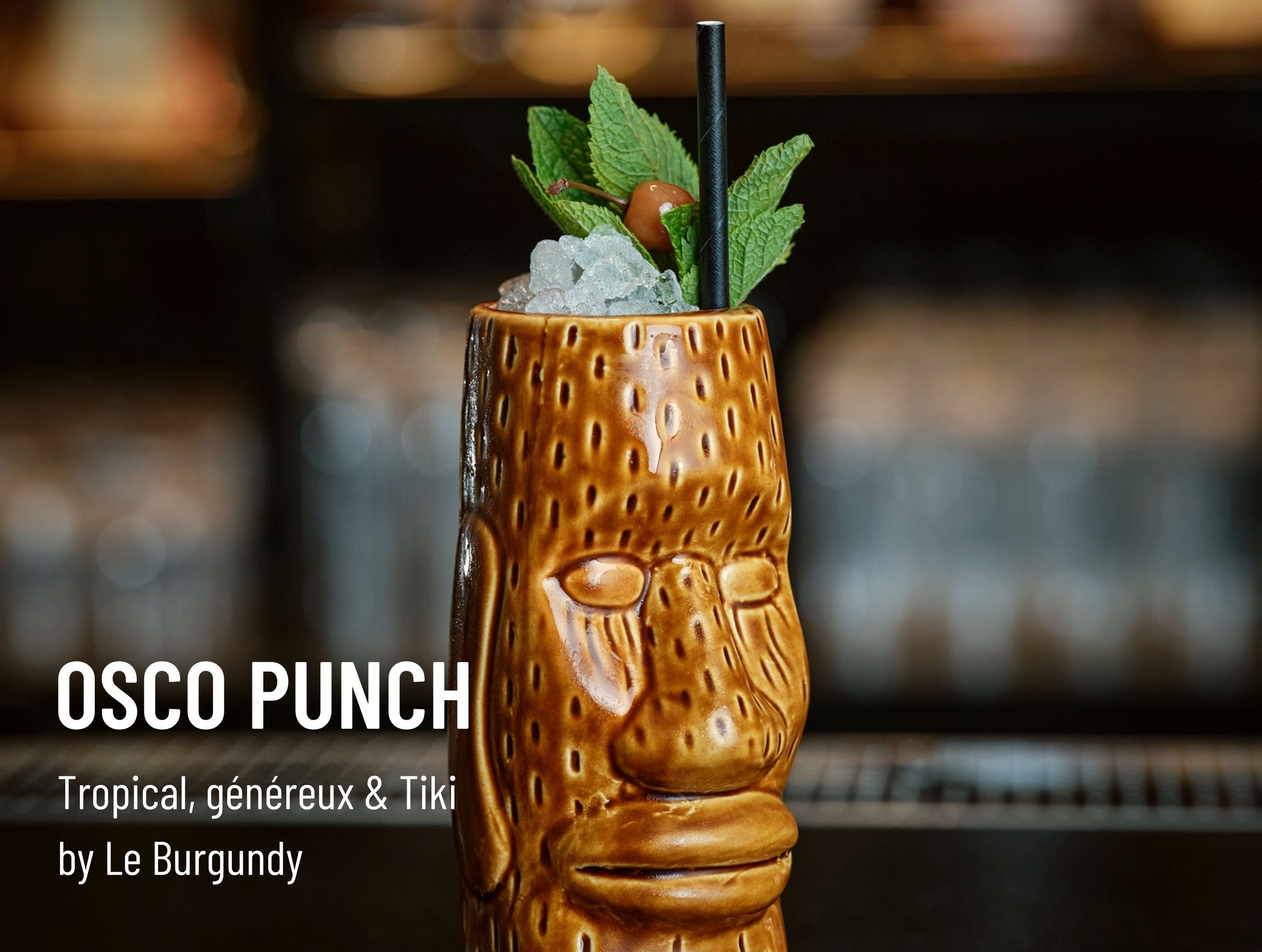 Cocktail OSCO Punch servi dans un verre tiki sculpté, décoré de menthe fraîche, ambiance exotique et festive